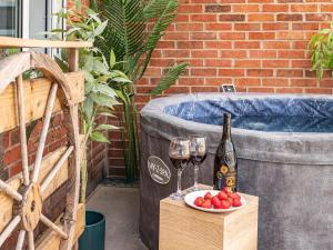 a bottle of wine and wine glasses on a crate next to a tub at Chic Riverside Retreat Salford 4bd free parking in Manchester