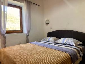 a bed with two pillows and a window in a room at Stone & Sea house in Valdanos