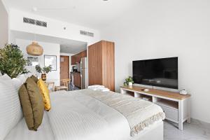 a bedroom with a large bed and a flat screen tv at Bright Boho Loft near Yas F1 Circuit & Airport in Abu Dhabi