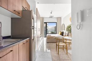 a kitchen with a refrigerator and a dining room at Bright Boho Loft near Yas F1 Circuit & Airport in Abu Dhabi