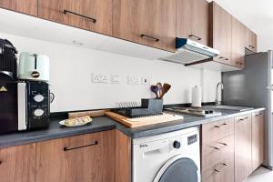 a kitchen with a washer and dryer on a counter at Bright Boho Loft near Yas F1 Circuit & Airport in Abu Dhabi +2 photos