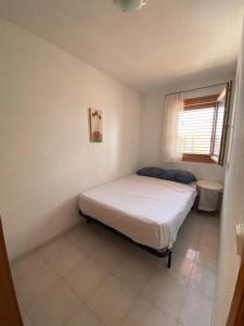 una piccola camera da letto con un letto e una finestra di Chalet en Peñiscola 160m con piscina y playa cerca 12 días mínimo de reserva a Peñíscola Altre 27 foto