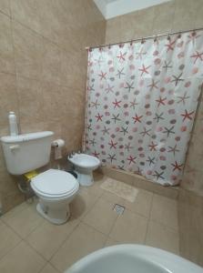 a bathroom with a toilet and a shower curtain at Finca LA Soñada in Santiago del Estero +6 photos