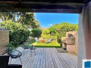 een terras met stoelen en een tafel en een tuin bij Villa Immortelle, Piscine, SPA, 500m plages et commerces in Lecci