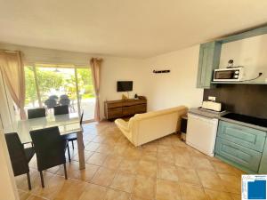 een woonkamer met een tafel en een keuken bij Villa Immortelle, Piscine, SPA, 500m plages et commerces in Lecci