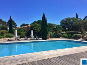 een zwembad met stoelen en parasols bij Villa Immortelle, Piscine, SPA, 500m plages et commerces in Lecci