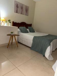 a bedroom with a large bed and a table at Sana - Chácara Canto do Tiê - 15 hospedes in Casimiro de Abreu