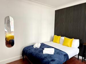 a bedroom with a bed with yellow and blue sheets at BA-Excellent Room fits 4 in Wembley in London
