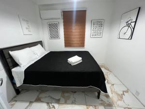 a bedroom with a large black bed in a room at VSS Minimalista in Arecibo - Sleek and Serene Stay Near Beaches in Arecibo