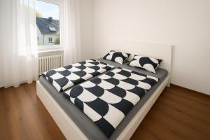 a bed with black and white pillows in a bedroom at Köln Pulheim 63 in Pulheim