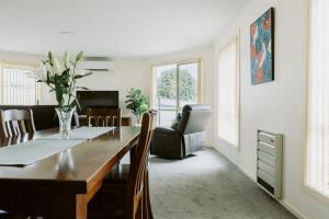 a dining room with a table and a living room at The Sanctuary Devonport in Devonport