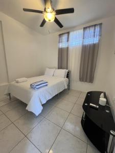 a bedroom with a bed and a ceiling fan at Surfer Steps Apartment in Aguadilla +16 photos