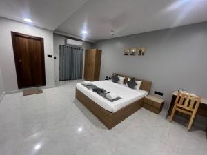 a bedroom with a bed and a table in it at Hotel Bhavans Elite in Rajiv Gandhi International Airport