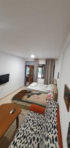 Sala de estar con 3 camas y mesa en Small apartment in Durres, en Durrës