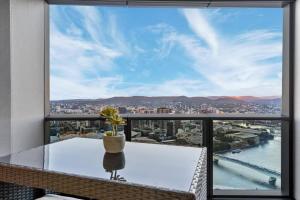 a balcony with a table and a view of the city at Luxurious 2 Bed Apartment with Pool, Sauna & Gym in Brisbane