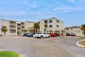 un parcheggio con auto parcheggiate davanti a un edificio di Belleair Beach Club 312 a Clearwater Beach