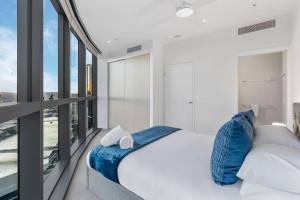 a bedroom with a large bed and large windows at Luxurious 2 Bed Apartment with Pool, Sauna & Gym in Brisbane +64 photos