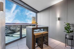 a room with a table and a large window at Luxurious 2 Bed Apartment with Pool, Sauna & Gym in Brisbane