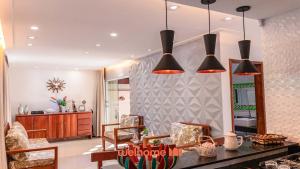 a living room with three lights hanging from the ceiling at Casa na Praia na Ponta da Ilha in Cacha Pregos +52 photos