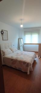 a bedroom with a large bed in a room with a window at Apartamento Muiño Bueu in Bueu
