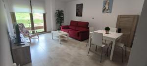 a living room with a red couch and a table at Apartamento Muiño Bueu in Bueu