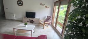 a living room with a couch and a tv and a table at Apartamento Muiño Bueu in Bueu