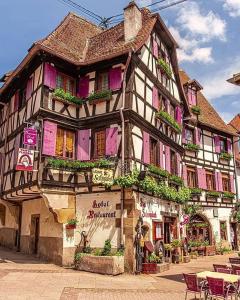 an old building with flowers on the side of it at Charmante petite maison in Bourgheim