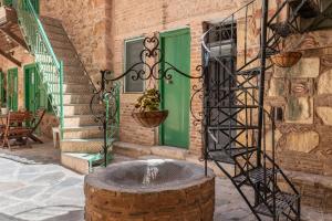 a fountain in front of a building with a green door at The Psyri Collection in Athens