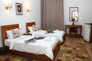 a hotel room with two beds and a mirror at Hyde Park House Hotel in Alexandria
