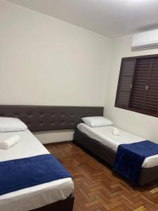 パスト・デ・ミナスにあるWANDER inn HOTELのベッド2台と窓のある寝室
