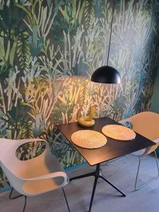a dining table with two chairs and a black lamp at Ferienwohnung Winter in Wasserburg am Bodensee