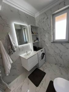 a white bathroom with a washing machine and a sink at Dany rent in Rădăuţi