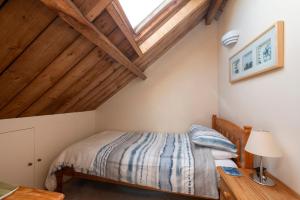 a bedroom with a bed and a wooden ceiling at Tanglewood Cottage - Lancombes House in Powerstock