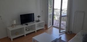 a living room with a flat screen tv on a white cabinet at Oleander Apartments in Selce