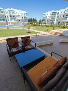 un patio con tavolo e sedie e alcuni edifici di Beautiful apartment at RIVIERA BEACH RESIDENCE CABO NEGRO a Cabo Negro