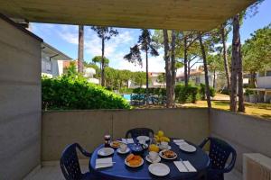 a blue table with plates of food on a patio at Apartments in Lignano 21597 in Lignano Sabbiadoro