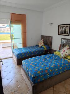 una camera da letto con due letti e una finestra di Beautiful apartment at RIVIERA BEACH RESIDENCE CABO NEGRO a Cabo Negro Altre 37 foto