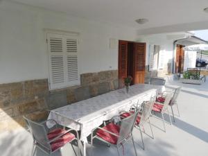 a large white table and chairs on a patio at RIBARIĆ in Banjol