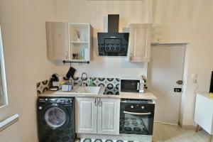 a kitchen with a washing machine and a microwave at Les Apparts du Pont Vert - lit double - WiFi - tout inclus - 6 in Troyes +6 photos