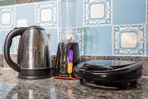 affeepot and a blender sitting on a kitchen counter at Estúdio aconchegante e funcional - cama casal ou 2 de solteiro - ar condicionado - wifi - netflix - cozinha in Brasilia