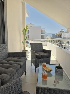 a balcony with a couch and chairs and a table at Idene Penthouse in Chania