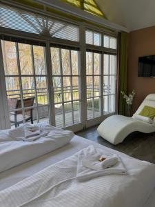 a bedroom with two beds and large windows at Strandresidenz Villa Verdi in Kühlungsborn