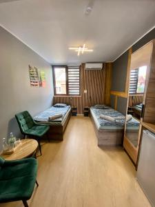 una stanza con due letti, un tavolo e delle sedie di Hostel Kandulski a Poznań