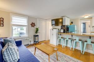 a living room with a blue couch and a kitchen at 1 Mi to Ferry Sea Street Cottage in Hyannis in Hyannis