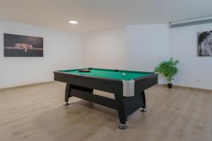a room with a pool table in front of a wall at Ammos Villa, beach villa with ocean view in Ribamar