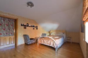 a bedroom with a bed and two chairs at Adelės Vila in Palanga