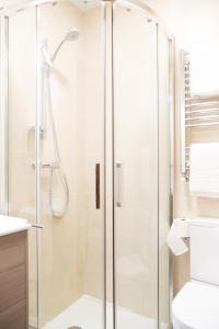 a shower with a glass door in a bathroom at Linares Rooms Santiago in Santiago de Compostela +27 photos