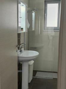 a white bathroom with a sink and a shower at Idene Penthouse in Chania +30 photos