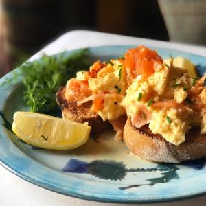 Un plato de comida con huevos sobre pan con una rodaja de limón. en Runnymede House, en Inverness