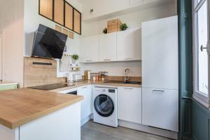 アングレットにあるAppartement Montdeville - Welkeysのキッチン(白いキャビネット、洗濯機、乾燥機付) +5枚の写真